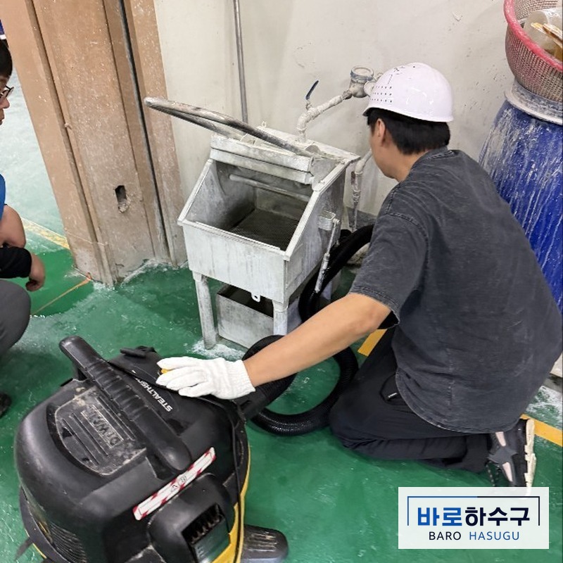 성남 수정구 공장 집수조 옆에서 석션 호스를 폐수 배관에 넣는 작업자