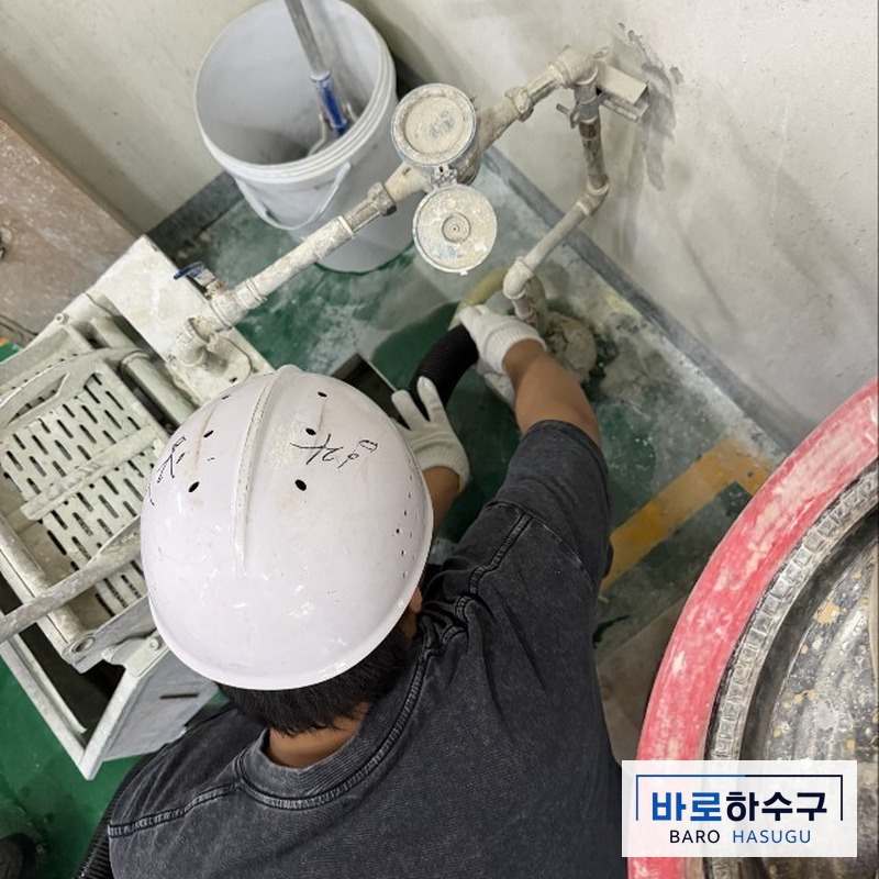성남 공장 폐수 배관 연결부를 손으로 확인하는 작업자